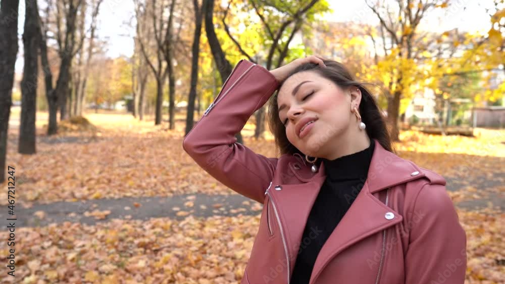 young brunette woman in pink leather jacket in autumn park outdoors young brunette woman in pink leather jacket in autumn park outdoors