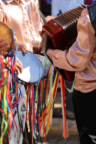 Group pf men in colorful clothes playing tambourine and music as part of religious festival of the state of Minas Gerais in Brazil photo