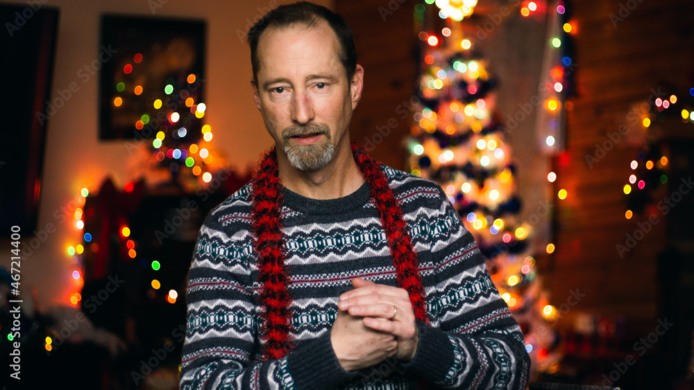 Fototapeta premium man cracking knuckles in front of Christmas tree