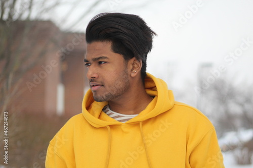 Man in yellow hoodie looking sideway photo
