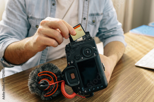 Man inserting memory card to a camera photo