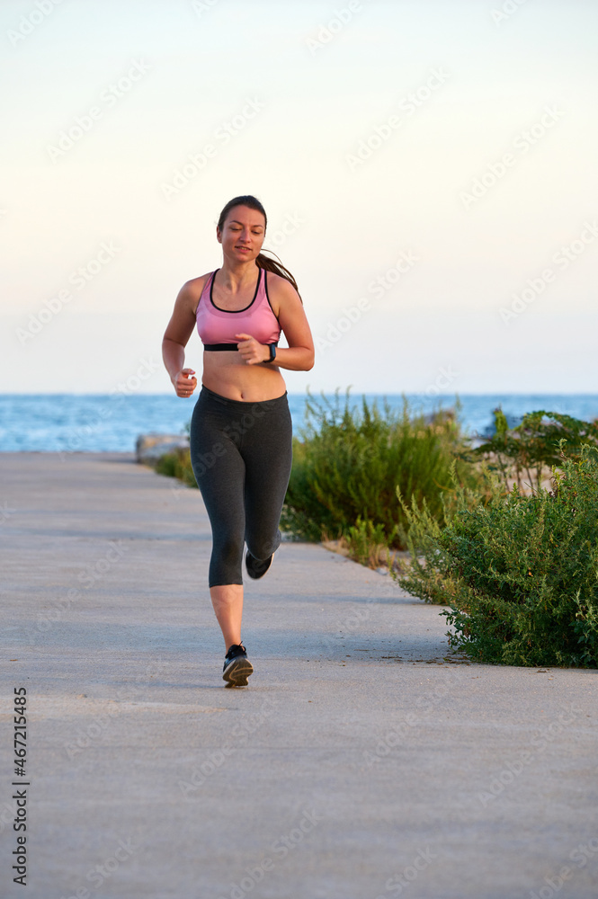 young woman running along the boardwalk at sunset young woman running along the boardwalk at sunset