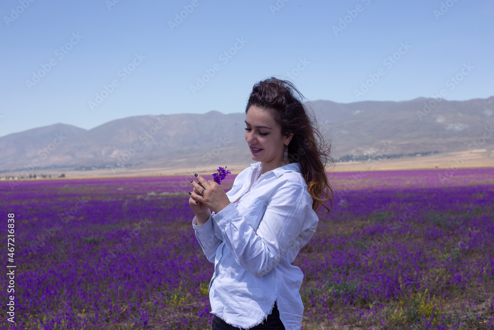 young,beautiful woman in violet flowers field