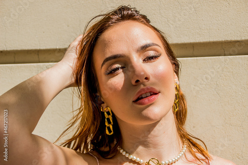 Portrait of young woman wearing golden earrings photo