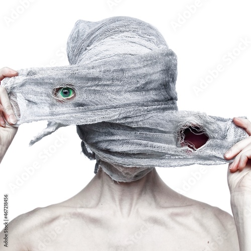 Topless person wearing mummy mask