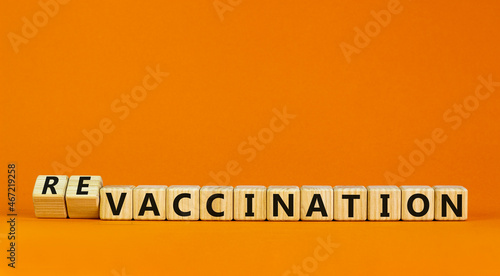 Revaccination or vaccination symbol. Turned cubes and changed the word vaccination to revaccination. Beautiful orange background, copy space. Medical, covid-19 pandemic revaccination concept. photo