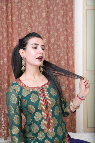 Young woman in green kurta holding her hair photo