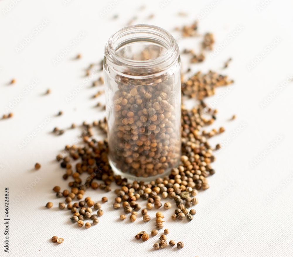 Clear Spice Jar with Coriander seeds on white background Clear Spice Jar with Coriander seeds on white background