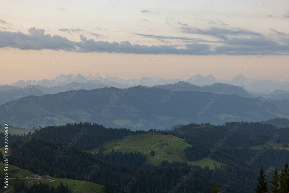 Amazing sunset at a wonderful landscape in Switzerland on a hill called Napf. Wonderful morning view with the alps in the horizon.