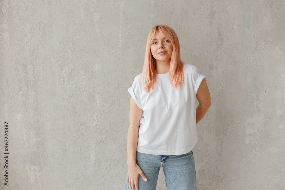 Young girl wearing blank white t-shirt. Concrete wall background Young girl wearing blank white t-shirt. Concrete wall background