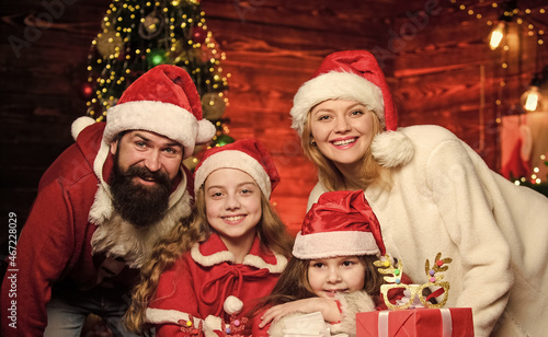 Colorful fun. Portrait loving family. merry christmas. Father and mother love kids. small children and parents in santa hat. lot of xmas present boxes. Happy family celebrate new year