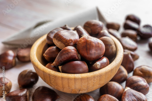 A pile of chestnuts filling a small wooden bowl ready to peel and eat