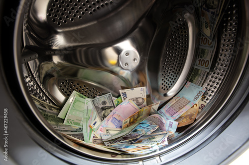 dollar, Ukrainian hryvnia and euro banknotes in washing machine