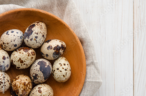 quail eggs in wooden plate over dark old wooden background