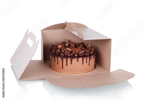 Chocolate cake decorated with sweets in carton box isolated on white