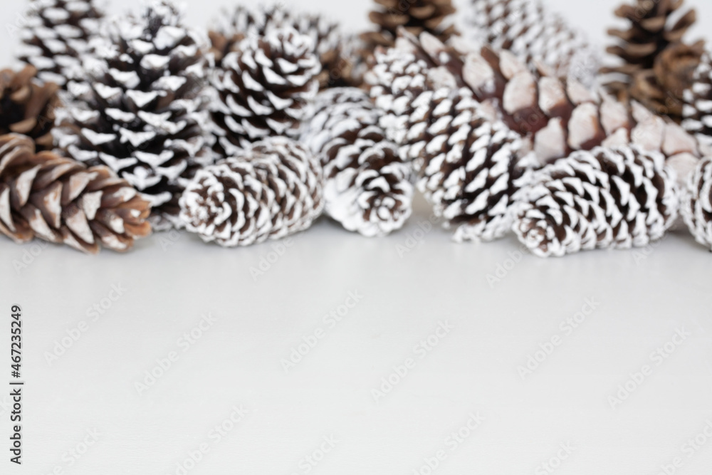White table background mockup with snow covered pine cones as decoration.