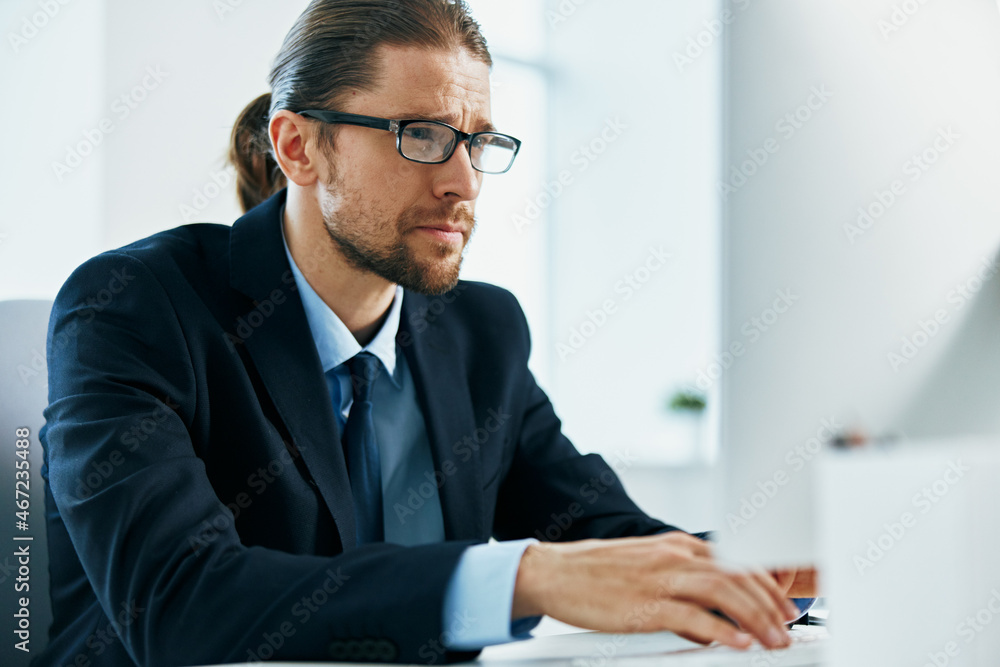 business man in a suit with glasses in the office at his desk business man in a suit with glasses in the office at his desk