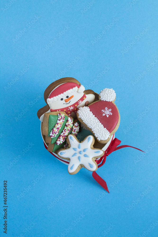 Top view of gift box with Christmas cookies on the blue background. Copy space. Location vertical.