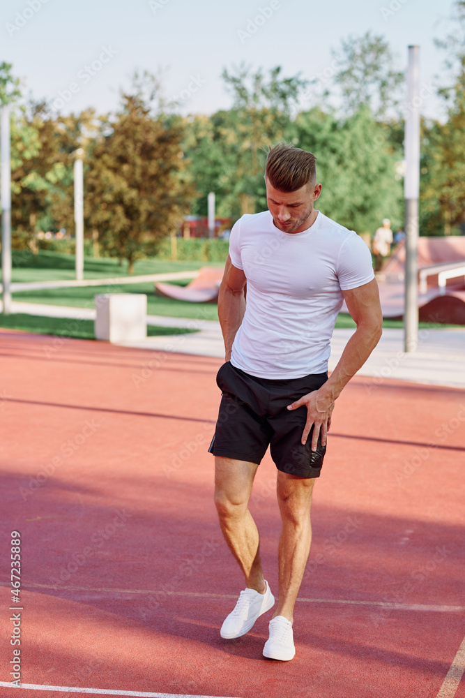 athletic men doing exercises on the sports ground in summer athletic men doing exercises on the sports ground in summer