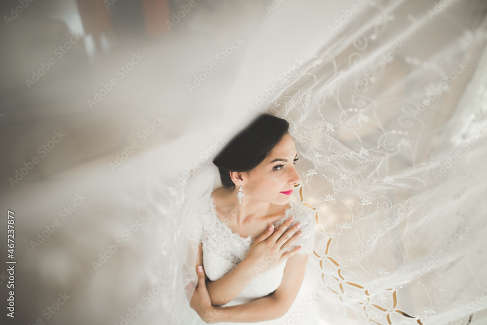Gorgeous bride in robe posing and preparing for the wedding ceremony face in a room Gorgeous bride in robe posing and preparing for the wedding ceremony face in a room