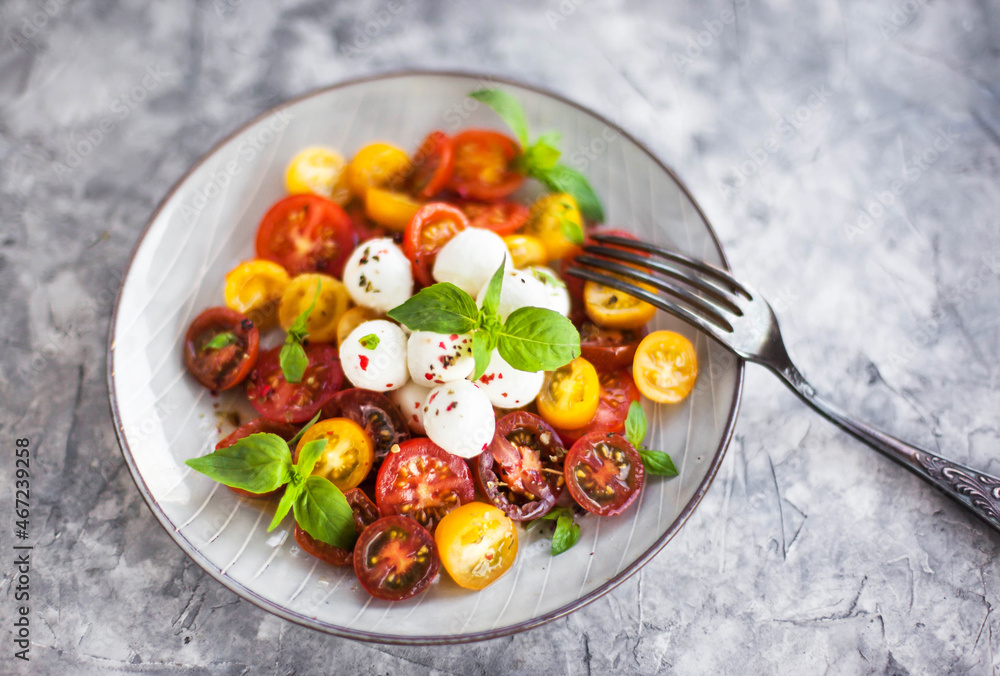 Red and yellow cherry tomato salad with baby mozzarella cheese and basil