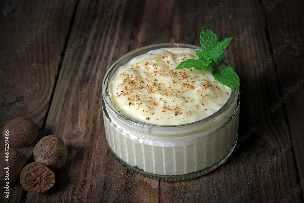ground nutmeg on top of a thick creamy clotted cream rice pudding. ground nutmeg on top of a thick creamy clotted cream rice pudding.