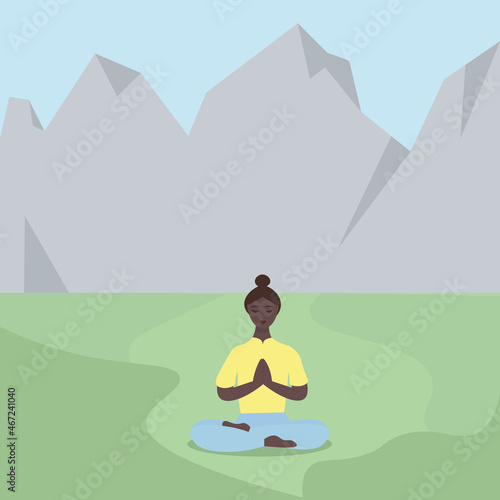 A young African-American woman does yoga among the mountains. The girl is sitting in the lotus position in nature. Playing sports on the street. Relaxation and detox from city life