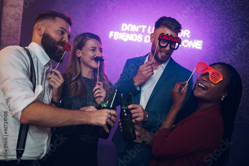 Happy group of friends dancing on a party in a club