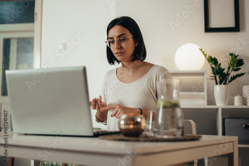 Woman using a laptop for an online meeting while working from home
