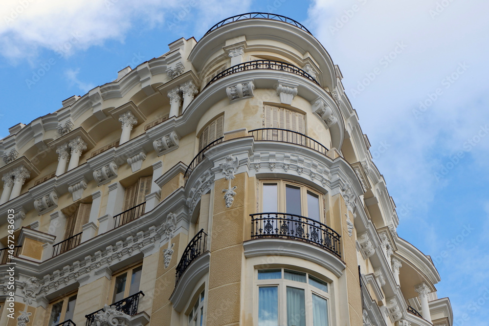 Corner of beige classical building on Gran Via street in Madrid, Spain