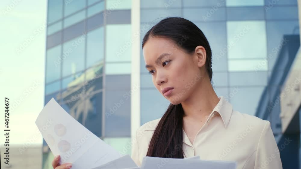 Chinese Business Lady Reading Papers Standing In Urban Area Outside Chinese Business Lady Reading Papers Standing In Urban Area Outside