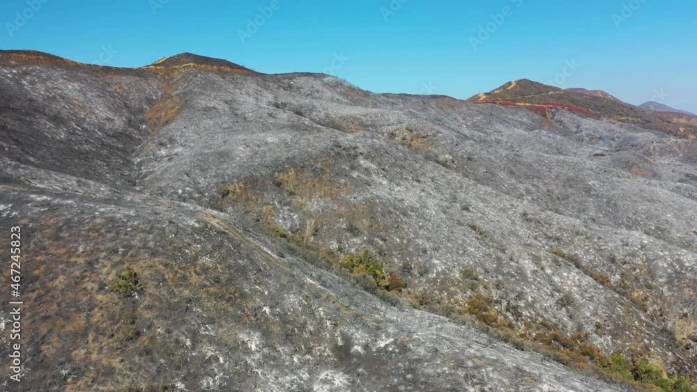 2021 - hills of red and black in Southern California covered in ash and fire retardant in the aftermath of a brush fire. 2021 - hills of red and black in Southern California covered in ash and fire retardant in the aftermath of a brush fire.