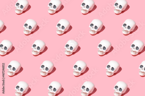 pattern from human skulls. Trending image on a pink background for the holiday Halloween