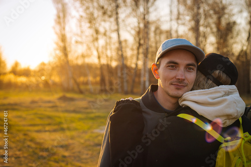 sunset portrait of  young romantic couple hugging outdoors - close up photo with selective focus
