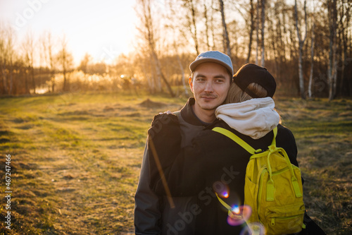 sunset portrait of  young romantic couple hugging outdoors - close up photo with selective focus