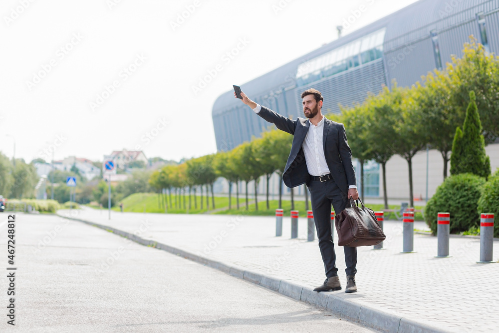 Fototapeta premium Male businessman can not catch free taxi at busy time. business man does not successfully stop a taxi on a city street. can't catch a car on the road waving his hand. standing on the sidewalk outside