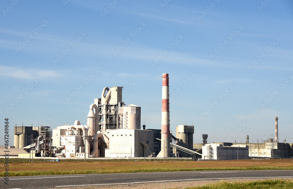 Cement plant with pipes. Сement production process and Industrial solution. Factory with smoke pipe. Chimney smokestack emission. Poor environment. Ecology concept, air and environmental pollution.