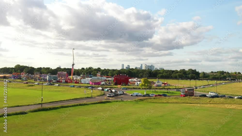 Cars driving on busy road around amusement park, modern skyscrapers in background Cars driving on busy road around amusement park, modern skyscrapers in background
