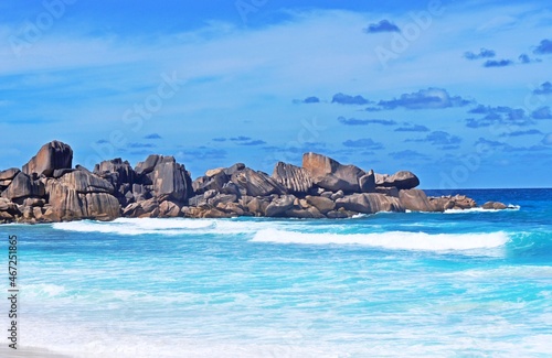 tropical island in the ocean. Grand Anse beach located on coast La Digue island in Seychelles. Beautiful beach with granite rocks. Breaking ocean waves. Grand Anse is the longest beach in La Digue. 