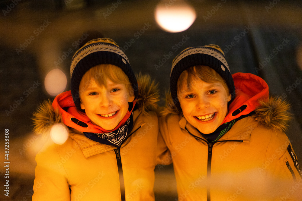 dwóch chłopców bliźniaki zima światła święta Stock Photo | Adobe Stock