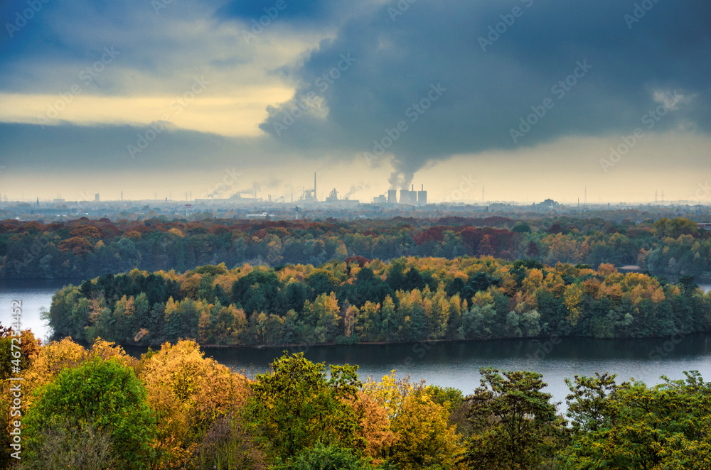 autumn landscape with lake in front of industrial backdrop