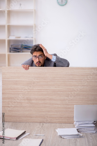 Young male employee working overtime in the office