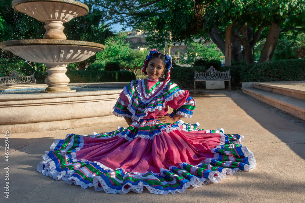 Naklejka premium BAILARINA TRADICIONAL MEXICANA SENTADA EN FUENTE DE AGUA