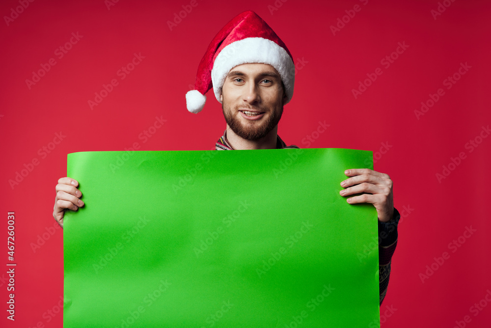 Cheerful man in a santa hat holding a banner holiday isolated background Cheerful man in a santa hat holding a banner holiday isolated background