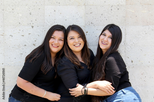 Three sisters dressed alike pose for the camera very happily in a photo session showing algeria, happiness and harmony in the family
