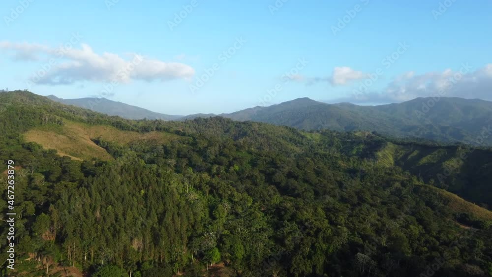 Aerial view of flight high in the mountains above the forest. Clear blue sky at sunset on the tropical island Aerial view of flight high in the mountains above the forest. Clear blue sky at sunset on the tropical island