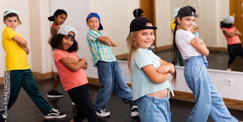Fotografía Multiethnic group of children in casual wear training hip hop movements in dance