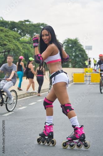 Latina woman skating in the street. With protection on elbows and knees post-pandemia.