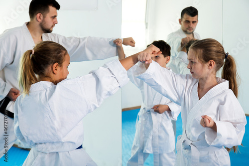 Happy children enjoying their trainings with coach at karate classes
