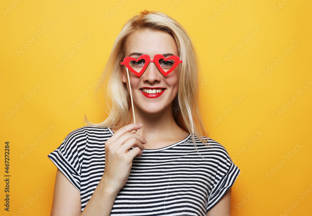 playful young woman ready for party over yellow background playful young woman ready for party over yellow background